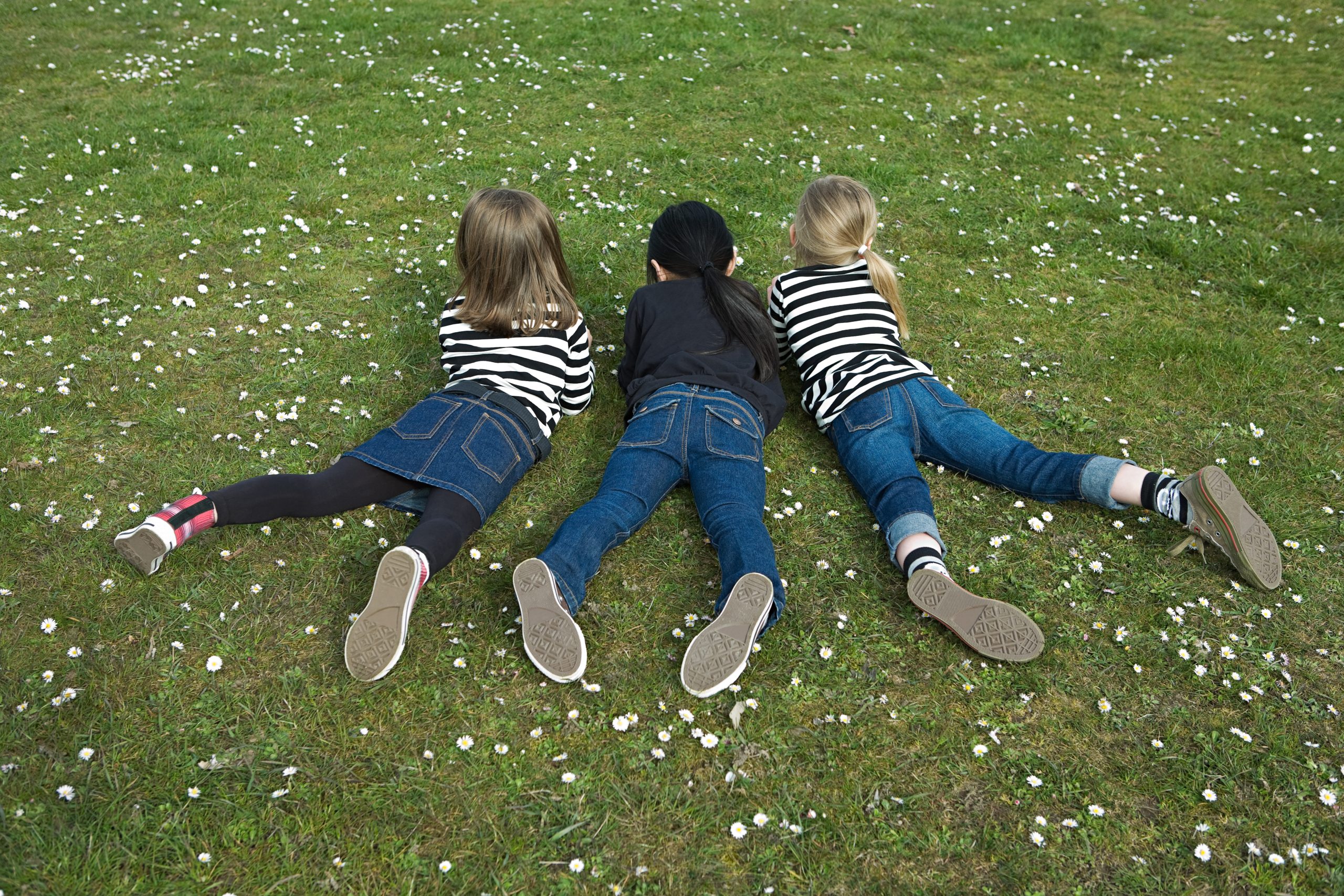 Three girls lying on grass